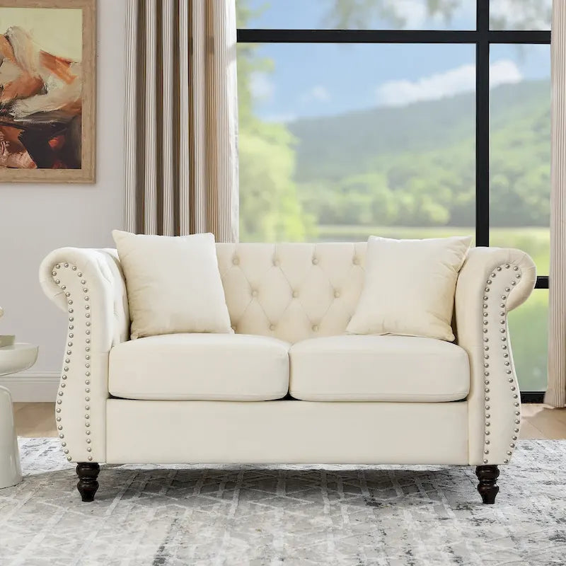 Causeuse chesterfield en velours, accoudoirs arrondis, garniture cloutée