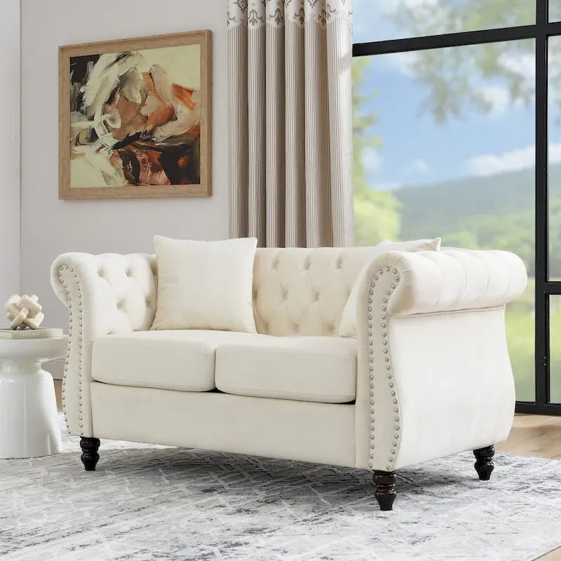 Causeuse chesterfield en velours, accoudoirs arrondis, garniture cloutée