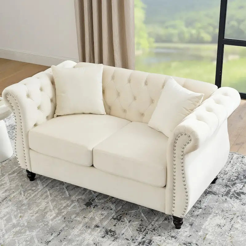 Causeuse chesterfield en velours, accoudoirs arrondis, garniture cloutée