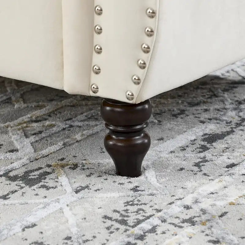 Causeuse chesterfield en velours, accoudoirs arrondis, garniture cloutée